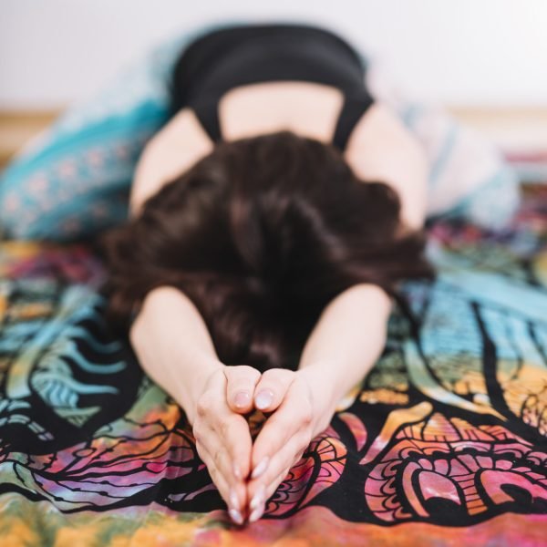 mujer joven practicando ejercicios de estiramiento en manta colorida mujer joven practicando ejercicios de estiramiento en manta colorida